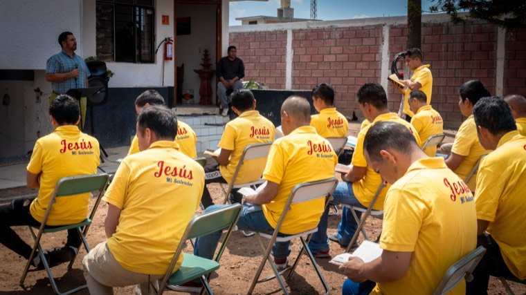 Residentes sentados en círculo al aire libre durante una sesión