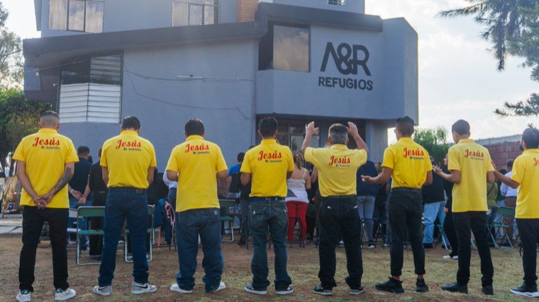 Residentes de espaldas frente a la casa de A&R Refugios