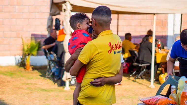Un residente carga a un niño durante el día de visita