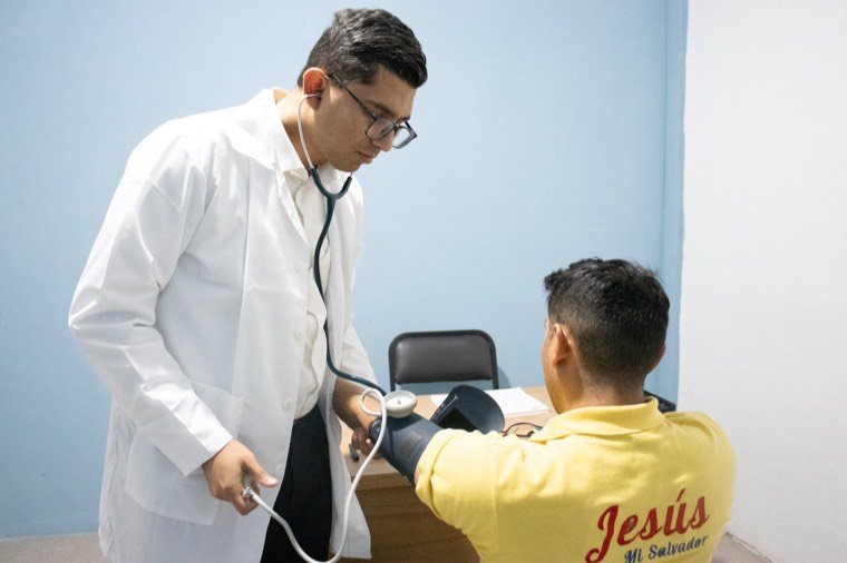Un médico toma la presión a un residente durante la revisión